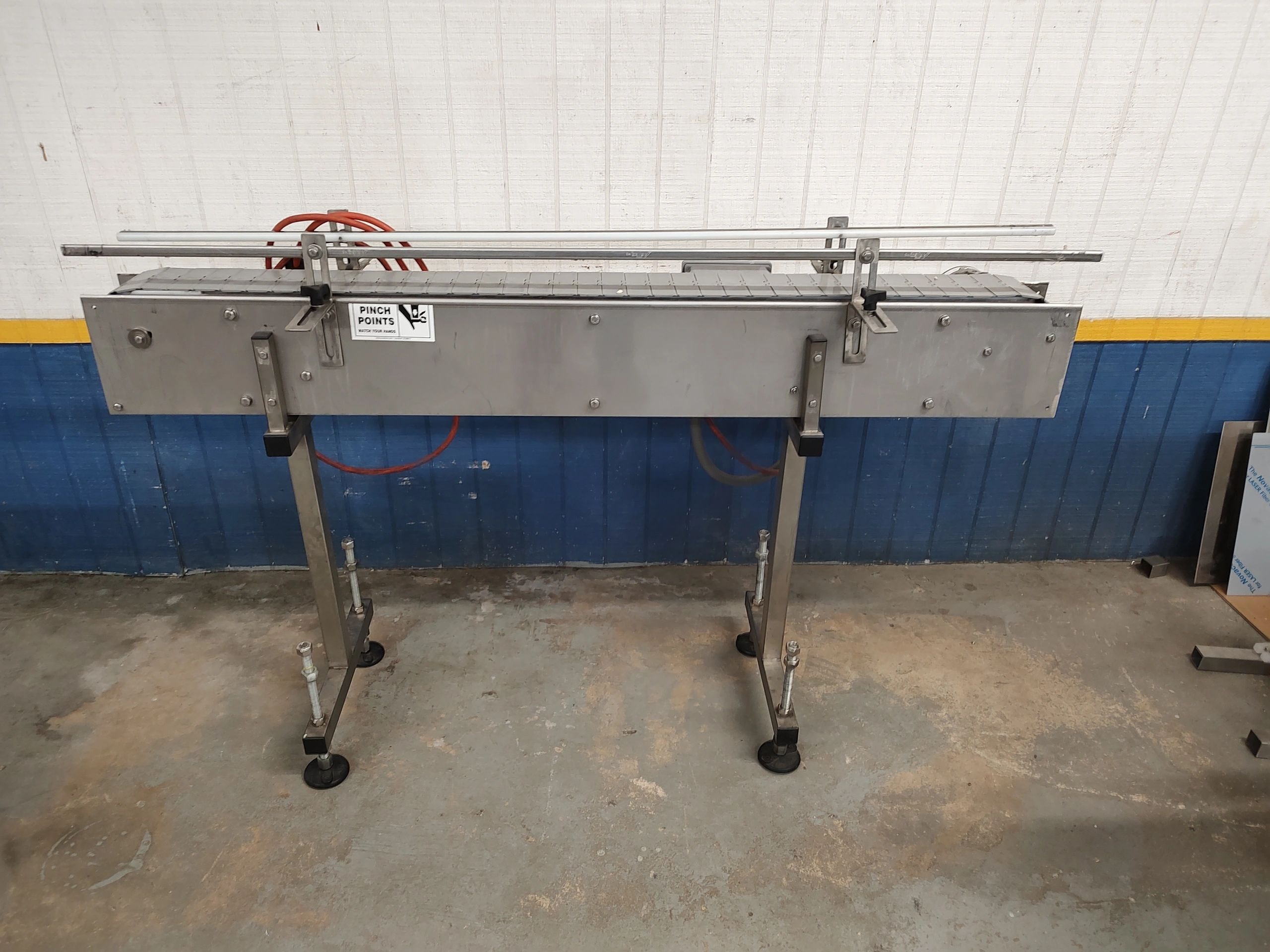Wide belt conveyor moving 5-gallon pails through a filling line