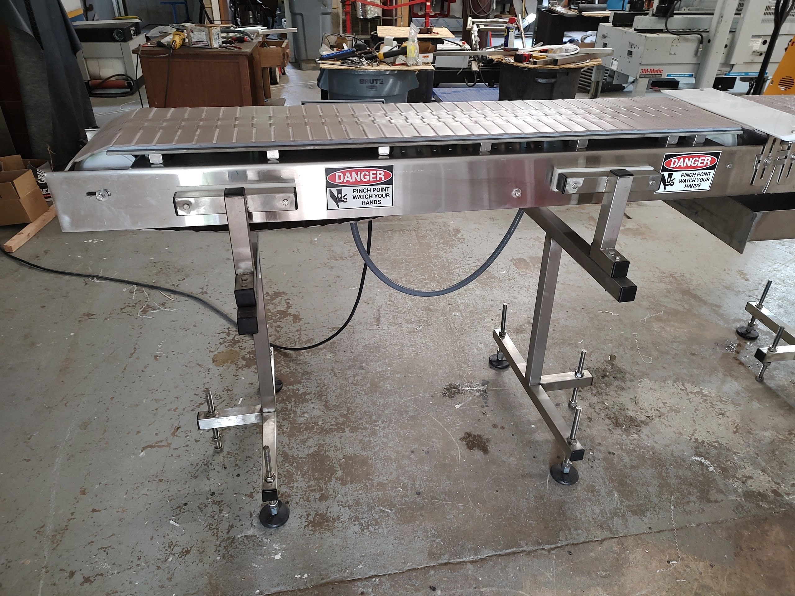 Used 5-foot bottle conveyor in stock — stainless steel, direct drive, variable speed